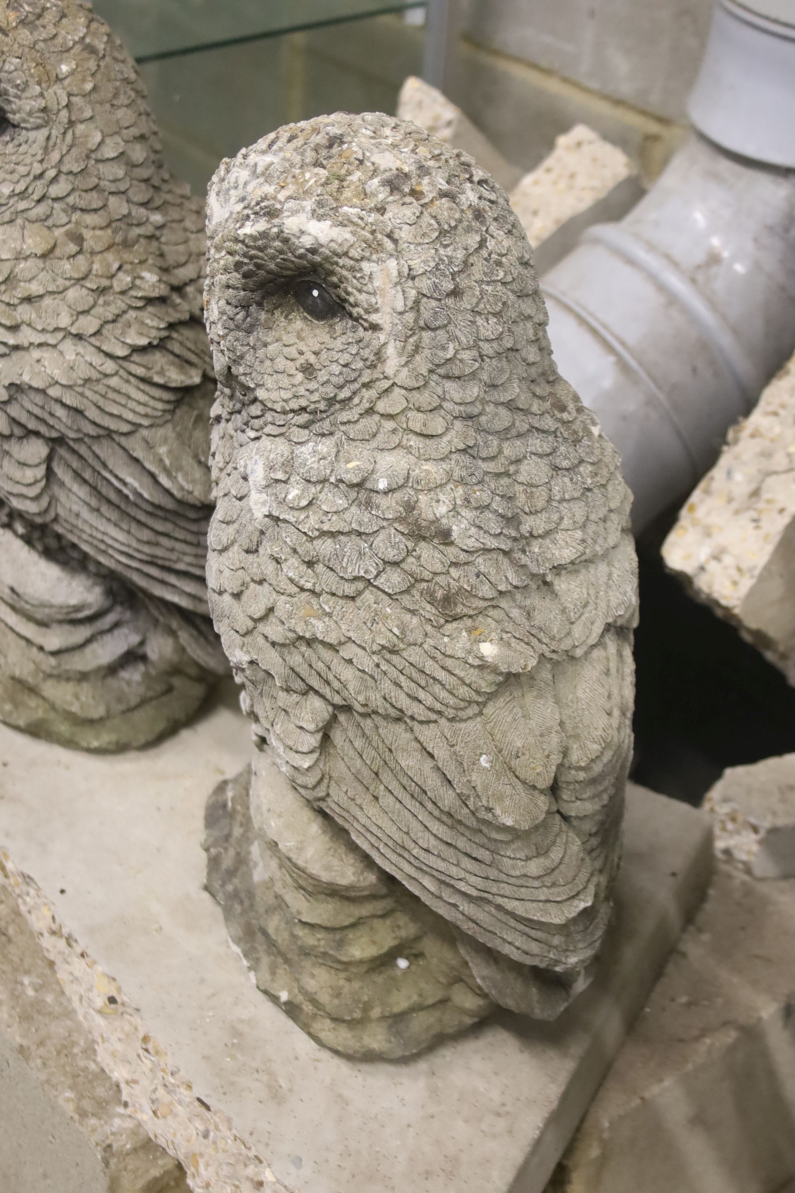 A pair of reconstituted stone garden ornaments modelled as owls, height 41cm